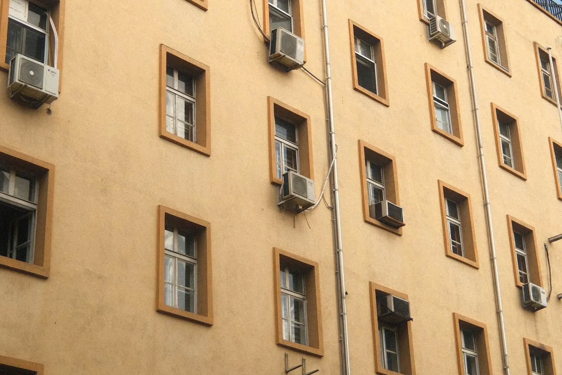A building facade with window air conditioning units projecting from several windows