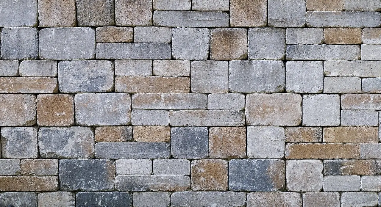 A wall of concrete blocks laid in staggered courses, joints offset between rows